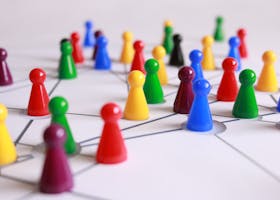 A strategic arrangement of colorful pawns connected on a game board, symbolizing networking and teamwork.